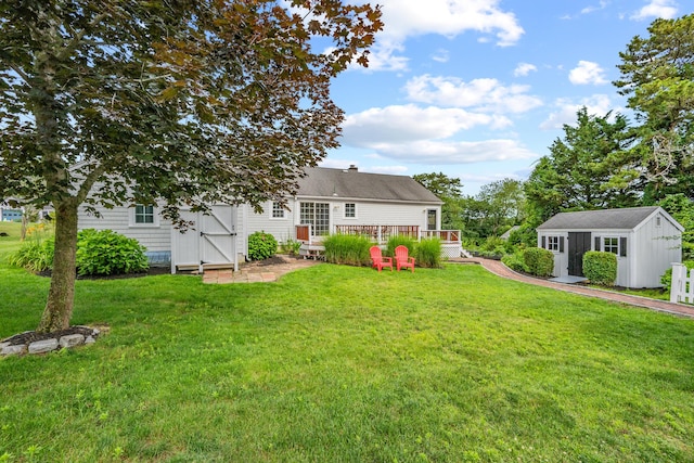 69 Joan Rd, Centerville, MA 02632 - rear view of property with a yard, a wooden deck, and a storage unit
