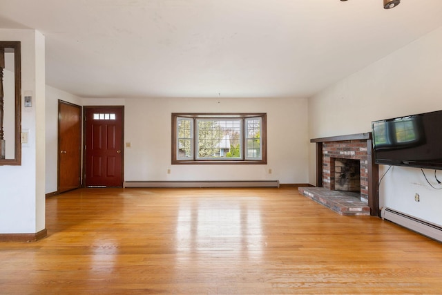 unfurnished living room with baseboard heating, light wood-type flooring, a fireplace, and baseboards
