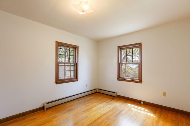 spare room with plenty of natural light, light wood-style floors, baseboards, and baseboard heating