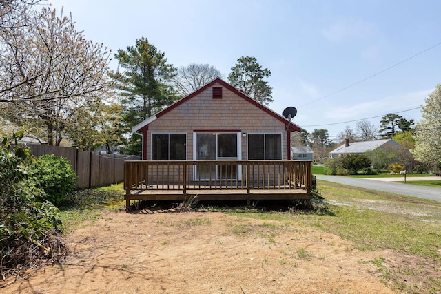 rear view of property with fence and a deck