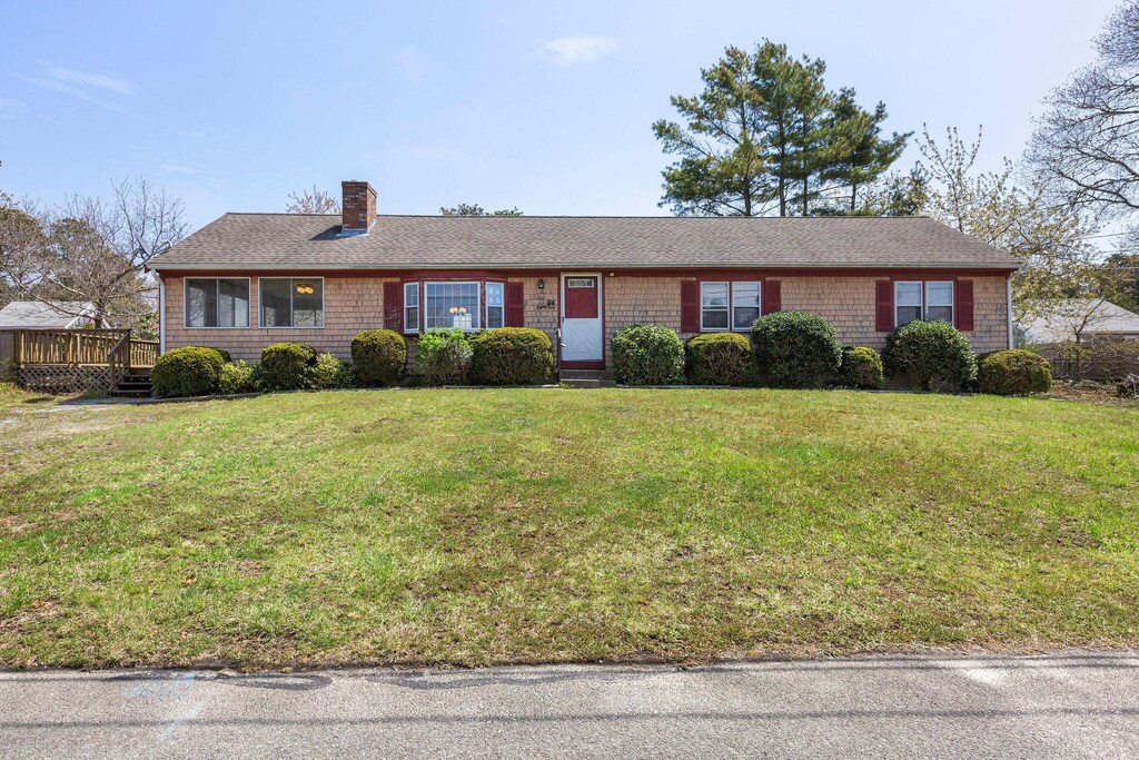 84 Cynthia Ln, Dennis Port, MA 02639 - ranch-style house featuring a chimney, a wooden deck, a front yard, and a shingled roof