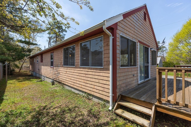 view of side of property with a wooden deck and a lawn