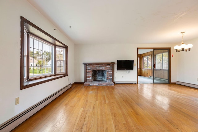 unfurnished living room featuring a baseboard radiator, a baseboard heating unit, a chandelier, light wood-style floors, and plenty of natural light
