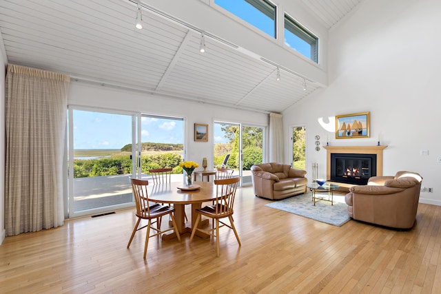 15 Hidden Valley Way, Wellfleet, MA 02667 - dining area featuring track lighting, high vaulted ceiling, light wood-style floors, and a glass covered fireplace