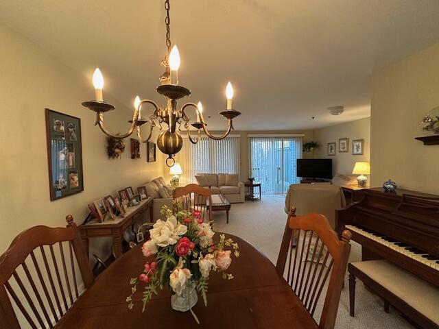 carpeted dining space with a notable chandelier