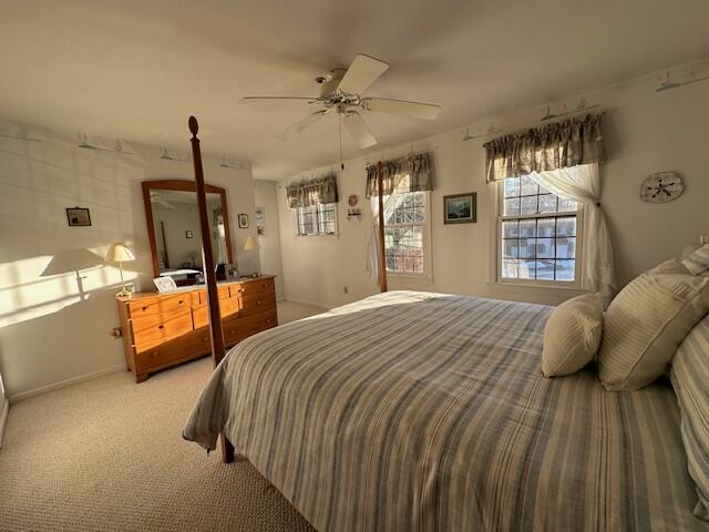 bedroom with light carpet and ceiling fan