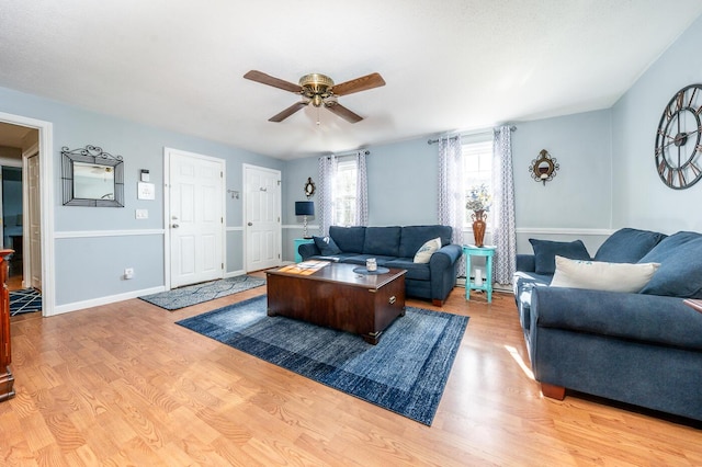 living room with light wood finished floors, baseboards, and a ceiling fan