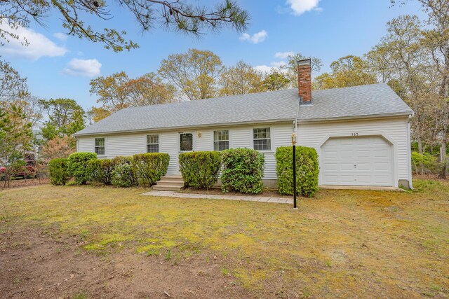 view of front of property with a chimney, a garage, a front yard, and a shingled roof