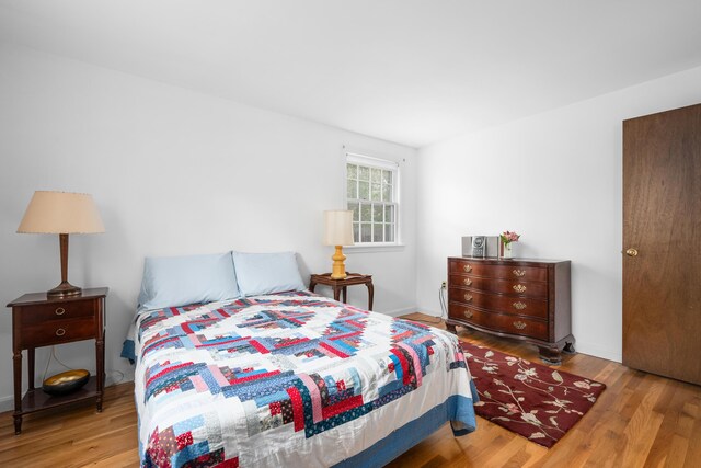 bedroom with wood finished floors and baseboards