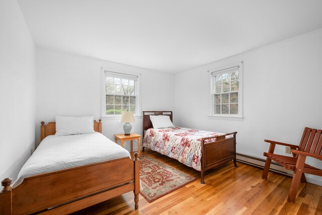 bedroom with multiple windows and light wood-style floors