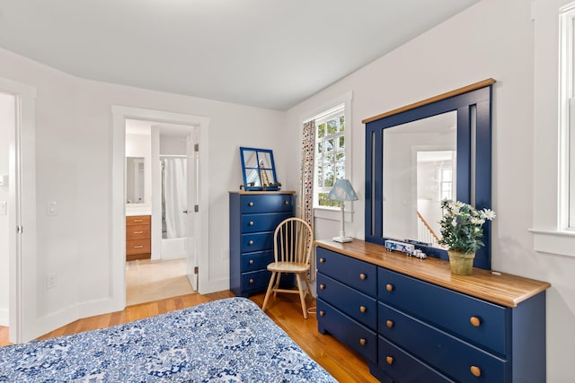 292 Stage Harbor Rd, Chatham, MA 02633 - bedroom featuring light wood-type flooring, baseboards, and connected bathroom