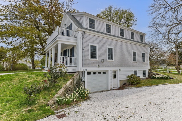 292 Stage Harbor Rd, Chatham, MA 02633 - view of side of property with a balcony, an attached garage, gravel driveway, and a lawn