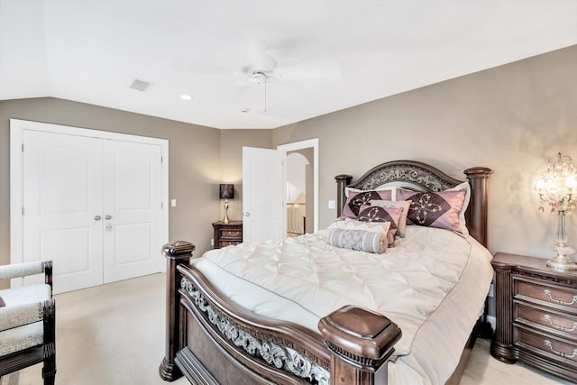 bedroom with light colored carpet, a ceiling fan, visible vents, vaulted ceiling, and a closet