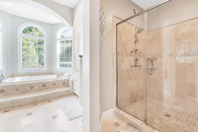 full bathroom featuring a garden tub, a shower stall, and tile patterned flooring