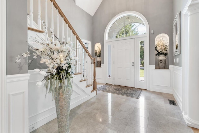 foyer entrance with a healthy amount of sunlight, visible vents, and a decorative wall