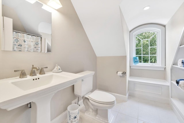 bathroom with lofted ceiling, baseboards, toilet, and tile patterned floors