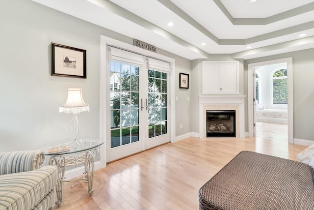 living room with light wood-type flooring, a glass covered fireplace, baseboards, and recessed lighting