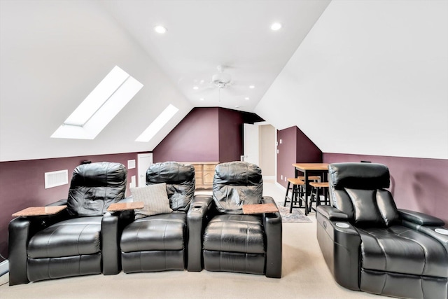 home theater featuring recessed lighting, light colored carpet, a ceiling fan, visible vents, and lofted ceiling with skylight