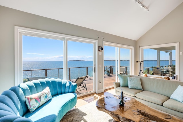 sunroom featuring vaulted ceiling, a water view, and track lighting