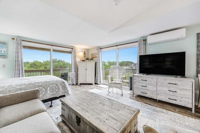 bedroom with hardwood / wood-style floors and a wall unit AC