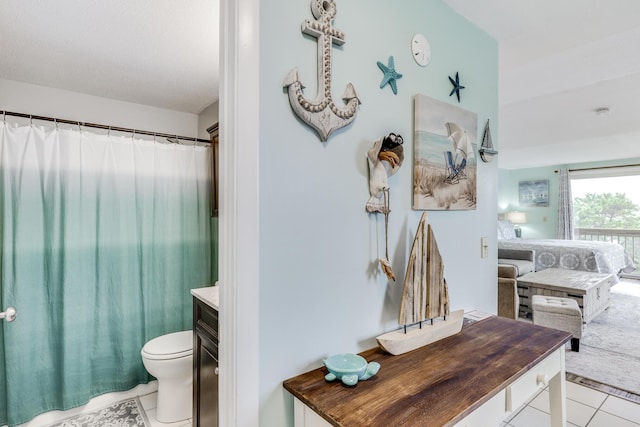 bathroom with tile patterned floors, vanity, toilet, and walk in shower