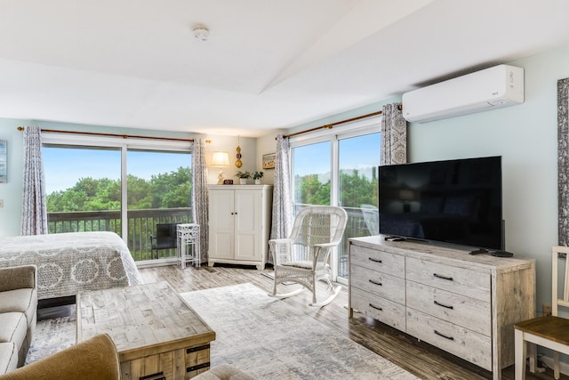 bedroom featuring multiple windows, a wall unit AC, and hardwood / wood-style floors