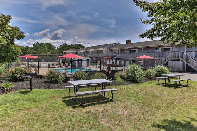 view of property's community featuring a pool and a lawn