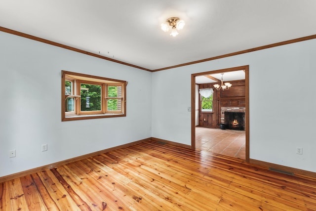 29 Windward Walk, Harwich Port, MA 02646 - spare room featuring light wood-style flooring, a chandelier, ornamental molding, baseboards, and a fireplace