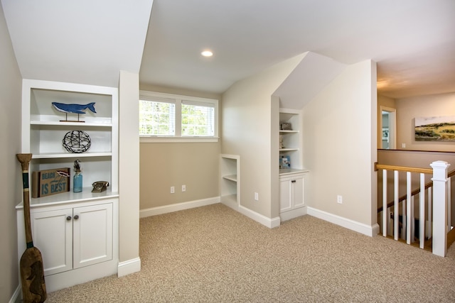 bonus room with built in features and light colored carpet