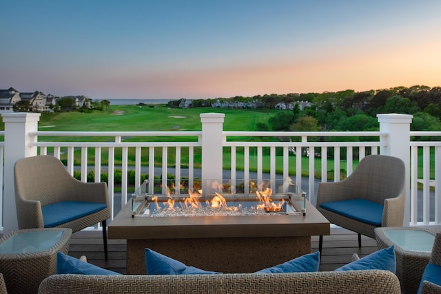 deck at dusk with an outdoor living space with a fire pit