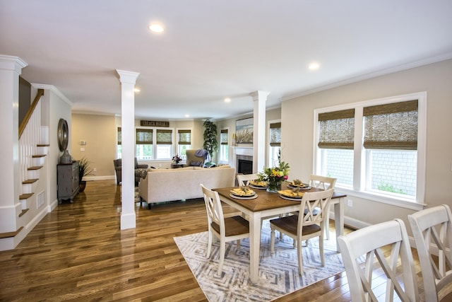 dining space featuring crown molding, dark wood-type flooring, and ornate columns