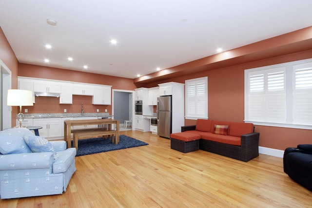 living room featuring baseboards, recessed lighting, and light wood-type flooring