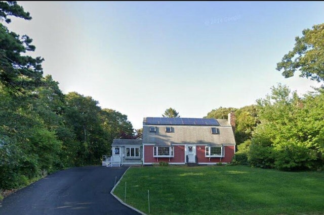 34 Charles Rd, Harwich, MA 02645 - dutch colonial with solar panels, a front yard, a gambrel roof, asphalt driveway, and a chimney