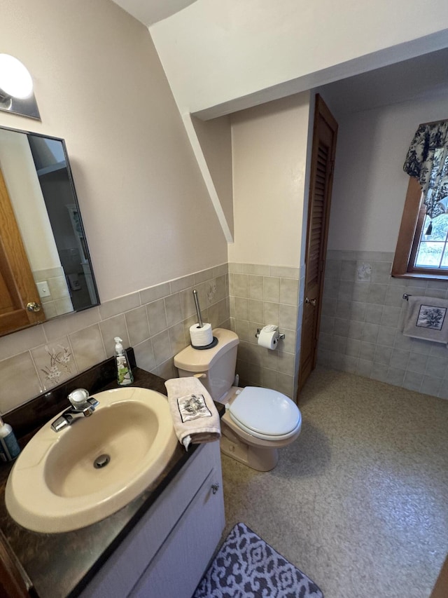 34 Charles Rd, Harwich, MA 02645 - bathroom featuring tile walls, toilet, vanity, and wainscoting