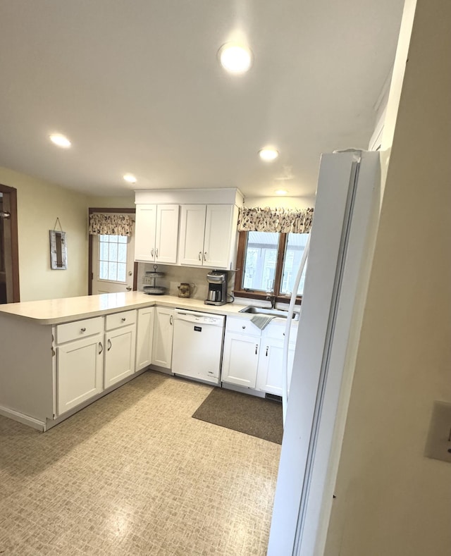 34 Charles Rd, Harwich, MA 02645 - kitchen with white appliances, a peninsula, recessed lighting, a sink, and white cabinets