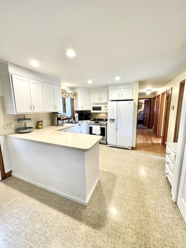 34 Charles Rd, Harwich, MA 02645 - kitchen with stainless steel appliances, a peninsula, a sink, light countertops, and recessed lighting