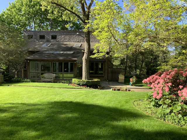 29 Sturgis Ln, Barnstable, MA 02630 - rear view of property featuring a lawn, a shingled roof, and a sunroom