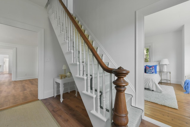stairs featuring wood finished floors and baseboards
