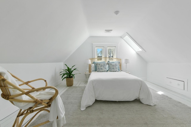 carpeted bedroom with visible vents and vaulted ceiling with skylight