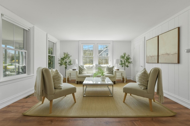 sitting room featuring wood finished floors and a decorative wall