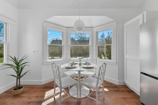 dining space with wood finished floors and baseboards