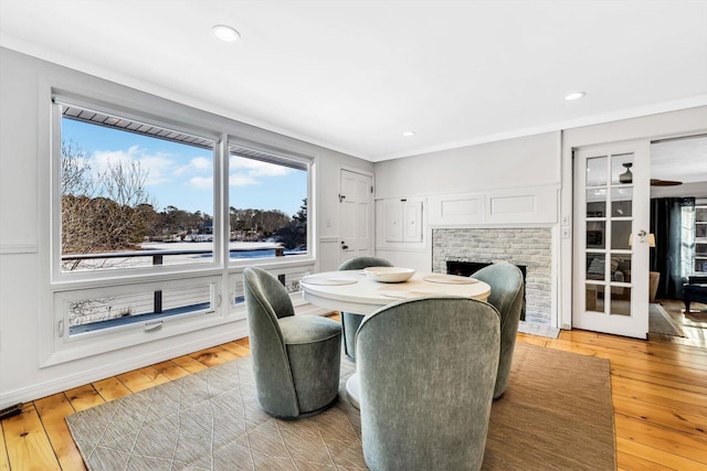 dining space with a brick fireplace and light hardwood / wood-style floors