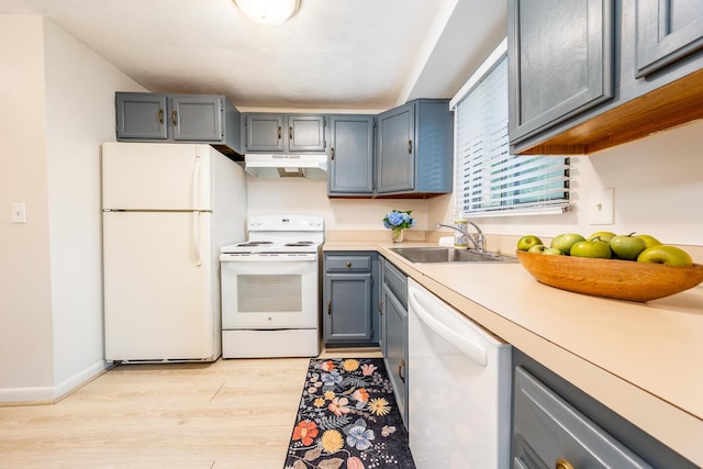 329 W Main St Unit 30, Hyannis, MA 02601 - kitchen with white appliances, under cabinet range hood, light wood-style floors, light countertops, and gray cabinetry