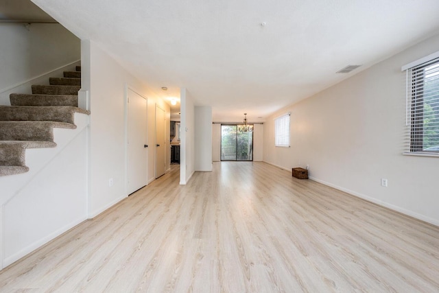 329 W Main St Unit 30, Hyannis, MA 02601 - unfurnished living room with a chandelier, light wood finished floors, and stairs