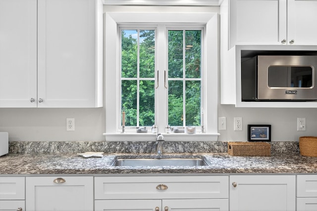908 W Falmouth Hwy, Falmouth, MA 02540 - kitchen with stainless steel microwave, white cabinetry, and dark stone counters