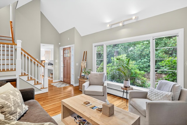 908 W Falmouth Hwy, Falmouth, MA 02540 - living room with stairs, wood finished floors, a baseboard radiator, high vaulted ceiling, and track lighting