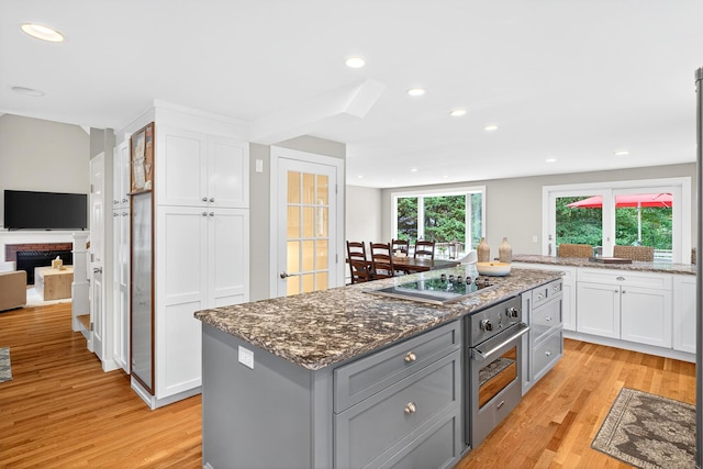 908 W Falmouth Hwy, Falmouth, MA 02540 - kitchen featuring stainless steel oven, black electric cooktop, gray cabinetry, white cabinetry, and light wood-type flooring