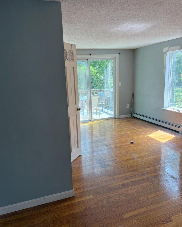 62 Musket Ln, Mashpee, MA 02649 - unfurnished room featuring baseboard heating, wood finished floors, and a textured ceiling