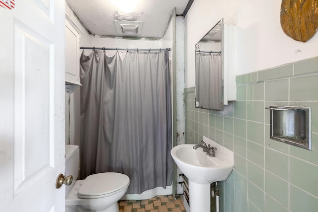 1424 Main St, Brewster, MA 02631 - bathroom featuring tile walls, toilet, curtained shower, and a sink