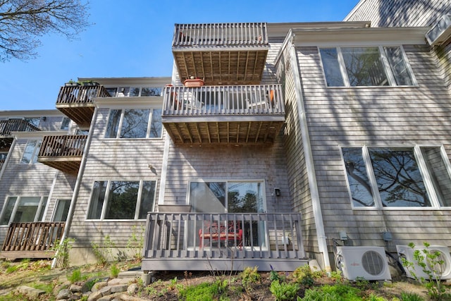 rear view of property featuring a balcony and ac unit